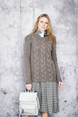 A woman is wearing a brown knitted sweater.