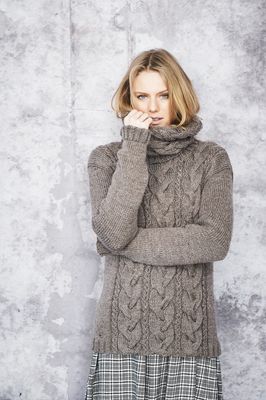 A woman is wearing a brown knitted sweater.