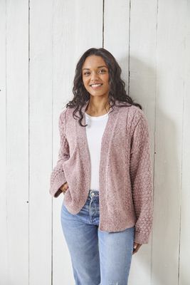 A woman is wearing a pink knitted cardigan.