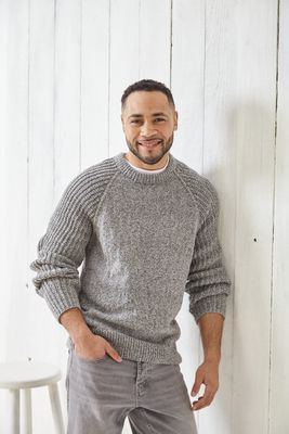 A man is wearing a grey knitted sweater.