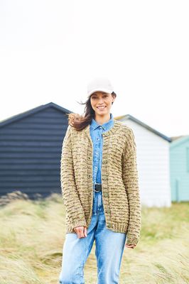 A woman is wearing a knitted cardigan in a variegated green yarn.