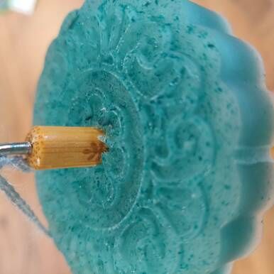 An aqua blue drop spindle.