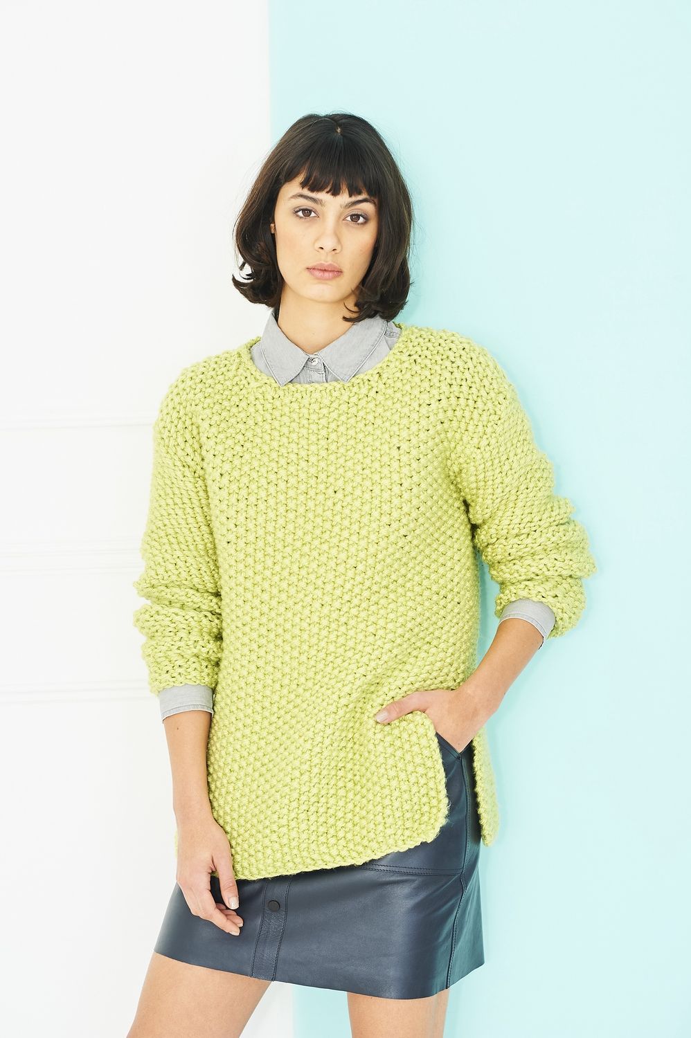 A woman is wearing a lime green knitted sweater.