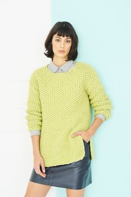A woman is wearing a lime green knitted sweater.