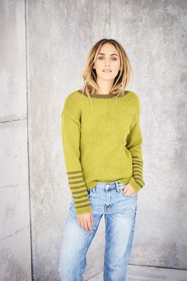 A woman is wearing a lime green knitted sweater with olive green stripes on the sleeves.