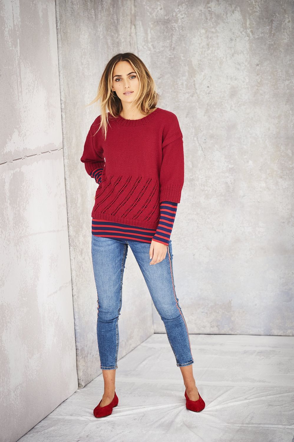 A woman is wearing a red knitted sweater.