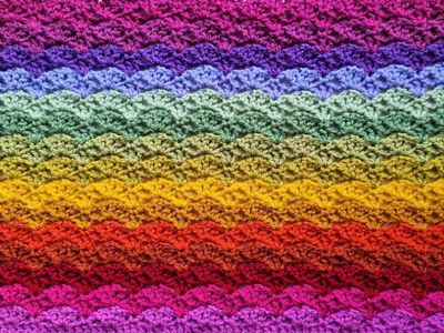 A close up of the crocheted blanket, made up of rainbow coloured rows.