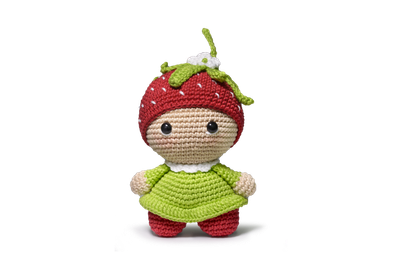 A green and red crocheted strawberry doll toy.