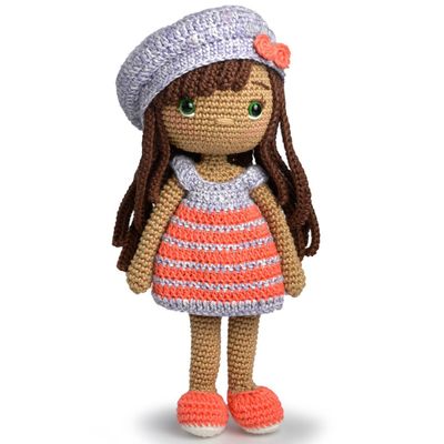 A crocheted doll, of a white girl with brown hair, a grey and orange stripy dress, a grey hat and orange shoes.