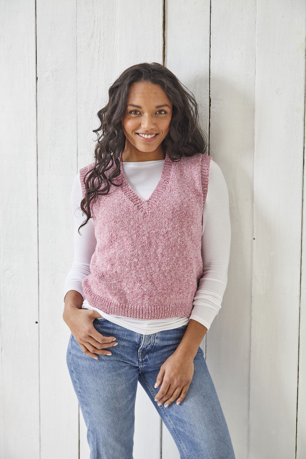 A woman is wearing a pink knitted tank top.