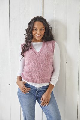 A woman is wearing a pink knitted tank top.