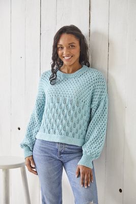 A woman is wearing a blue lace knitted sweater.