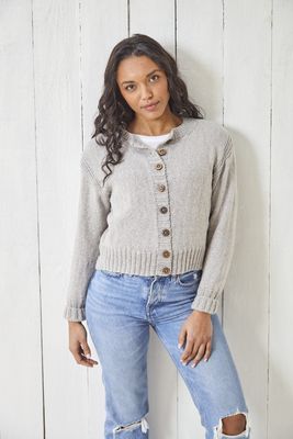 A woman is wearing a pale grey knitted cardigan.