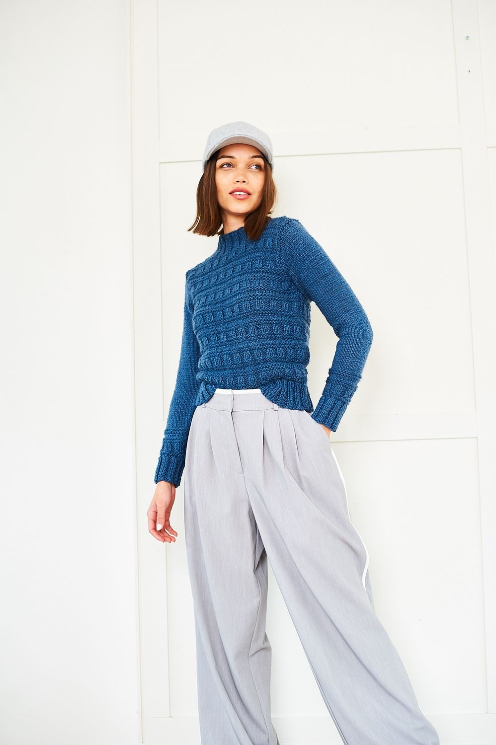 A woman is wearing a dark blue knitted sweater.