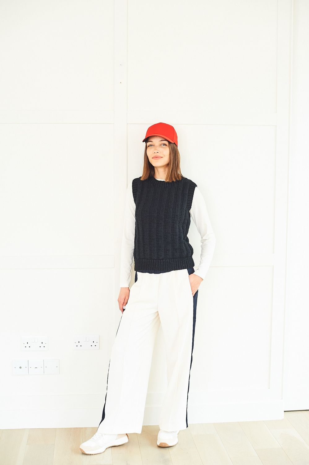 A woman is wearing a black round neck knitted tank top.