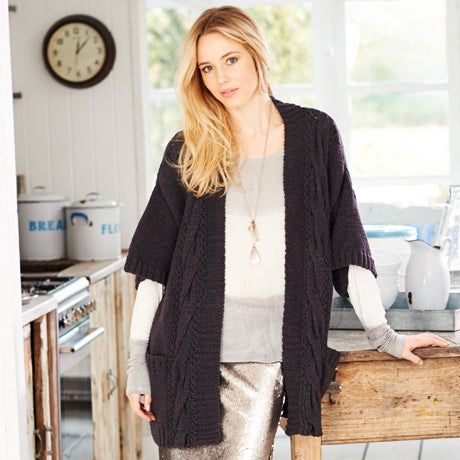 A woman is wearing a black knitted cardigan.