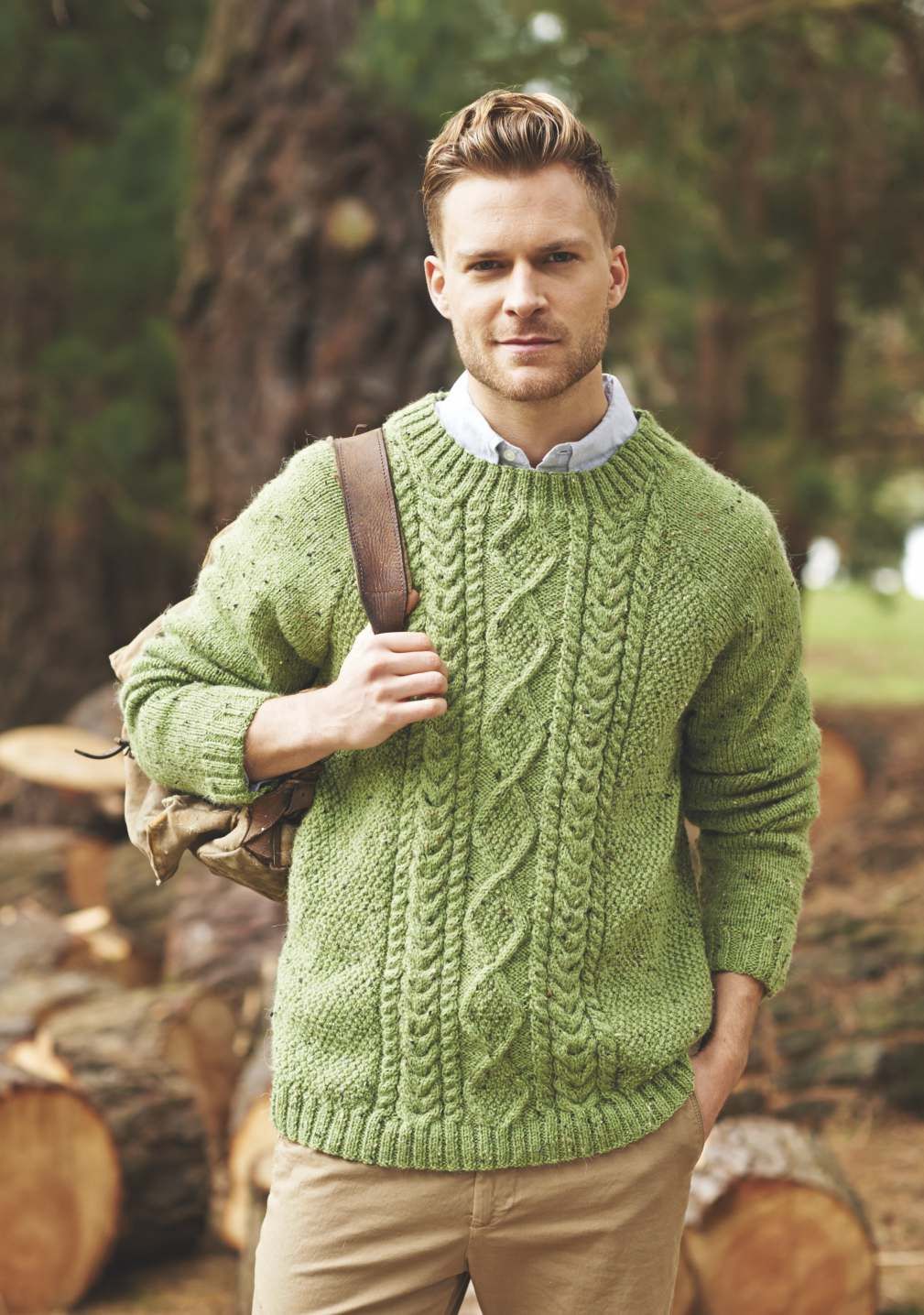 A man is wearing a green cable knit sweater.