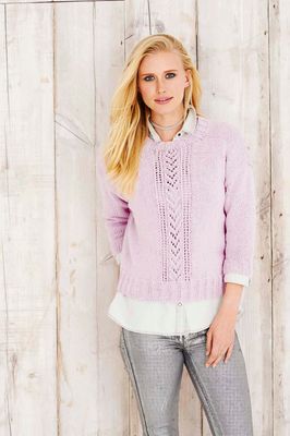 A woman is wearing a light pink knitted sweater.