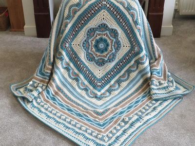 A blue, brown and cream crocheted blanket.