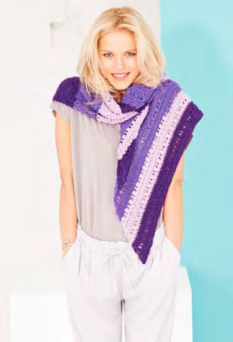 A woman is wearing a crocheted shawl in a variegated purple yarn.