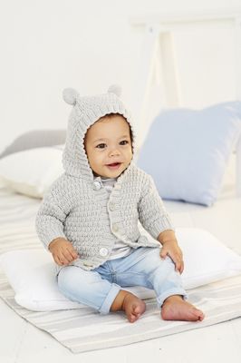 A baby is wearing a light grey knitted hooded cardigan, with bear ears on the hood.