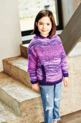A girl is wearing a knitted sweater in a variegated purple yarn.
