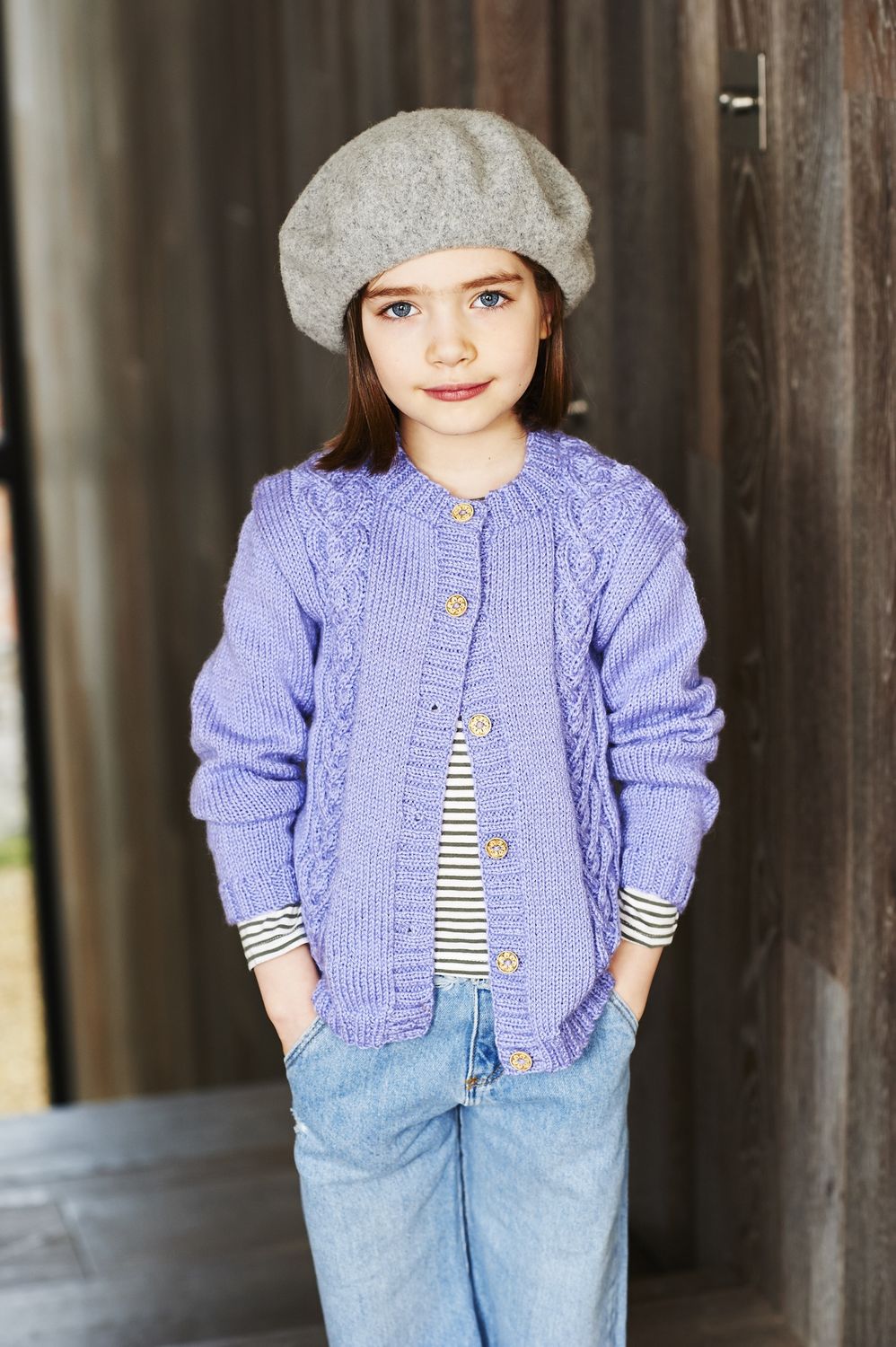 A girl is wearing a light purple knitted cardigan.
