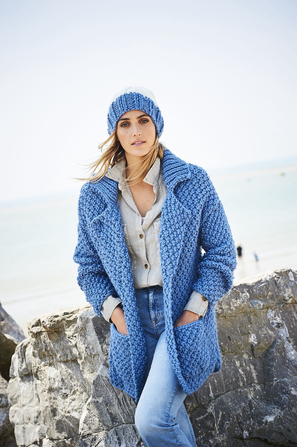 A woman is wearing a blue knitted cardigan.