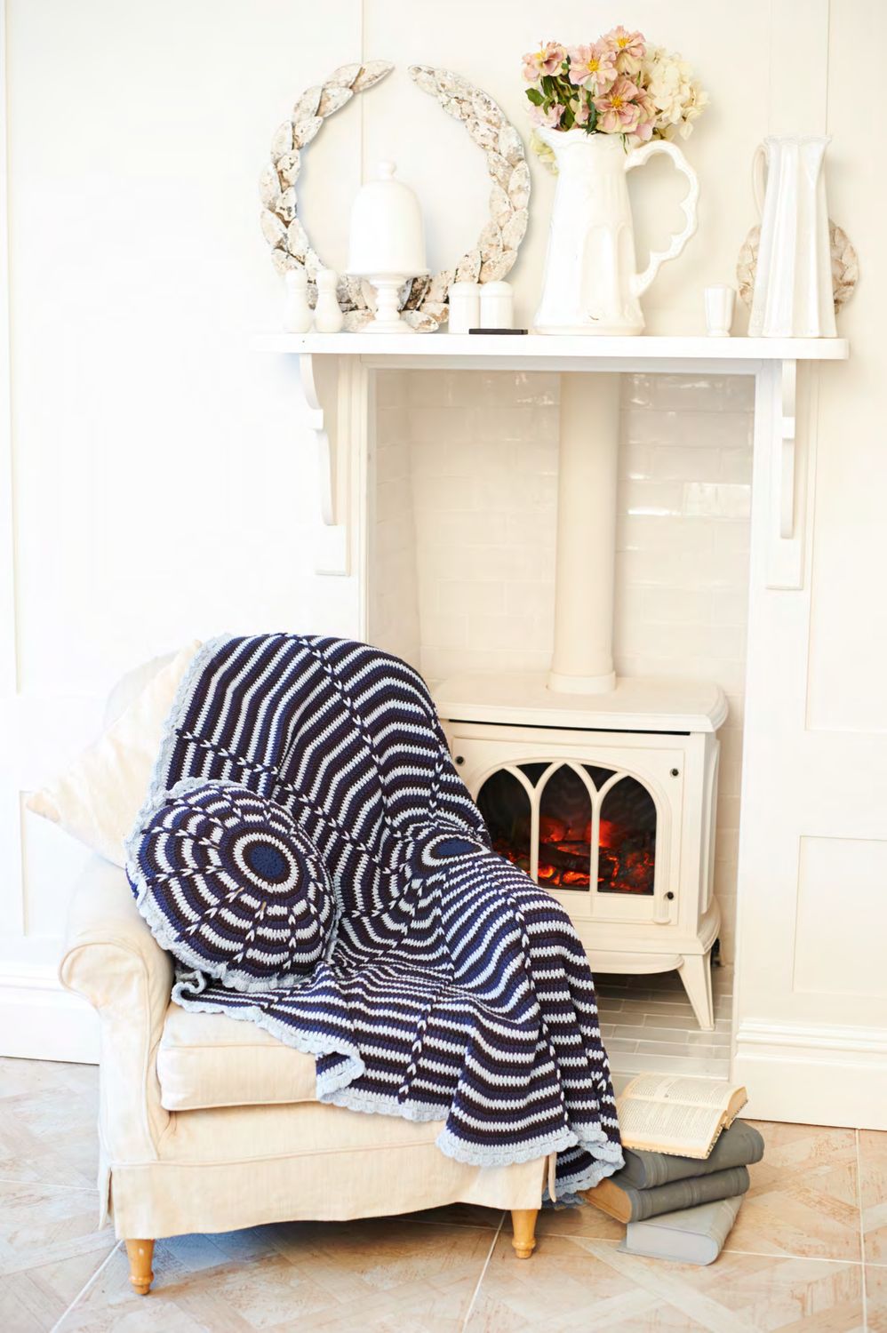 A crocheted circular blanket in light and navy blue with a matching cushion.