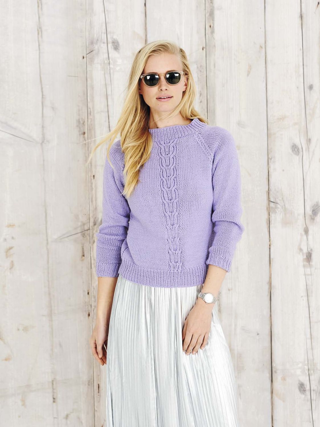 A woman is wearing a purple knitted sweater.