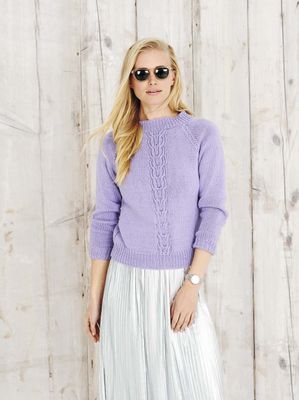 A woman is wearing a purple knitted sweater.