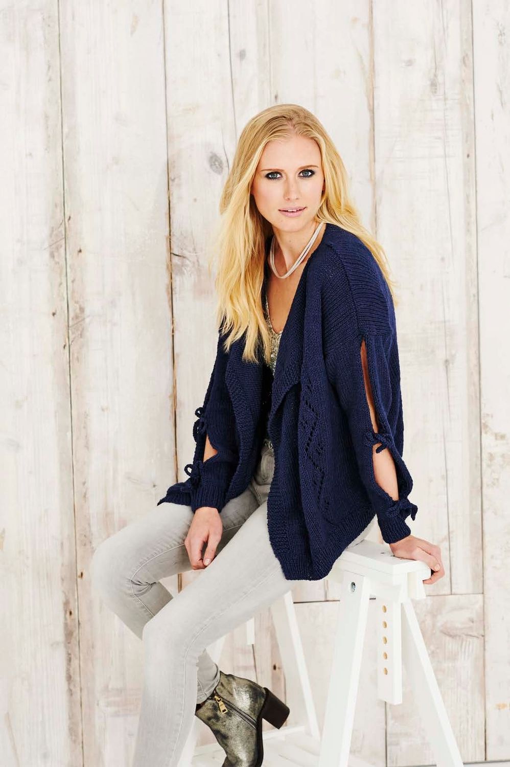 A woman is wearing a navy blue knitted cardigan.