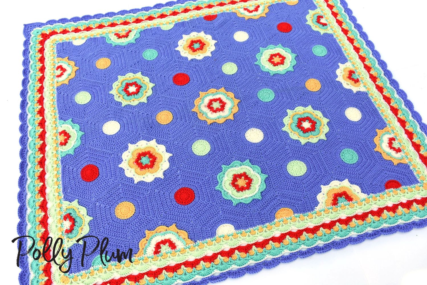 A crocheted blanket made up of hexagons in blue, green, yellow and red.