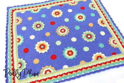 A crocheted blanket made up of hexagons in blue, green, yellow and red.