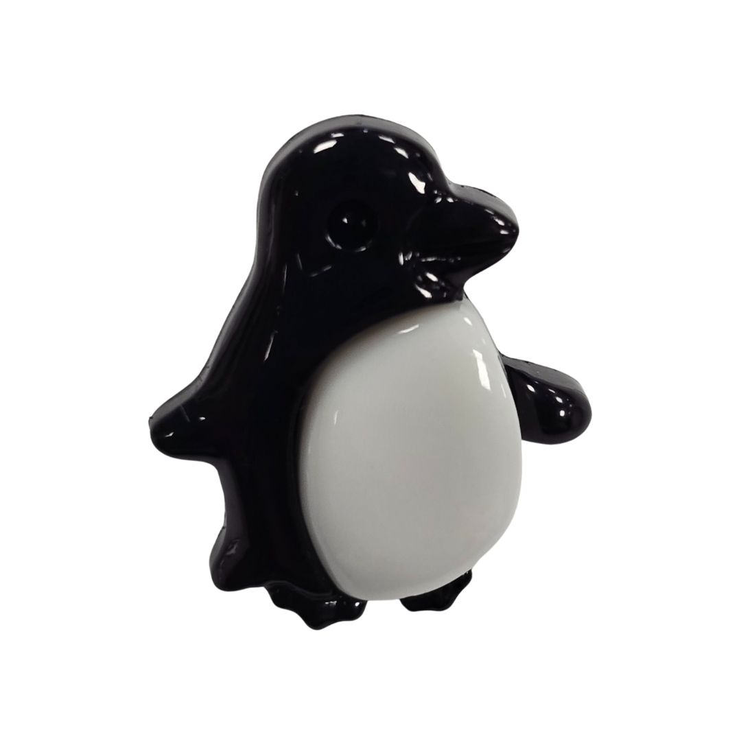 A black and white penguin shaped button.