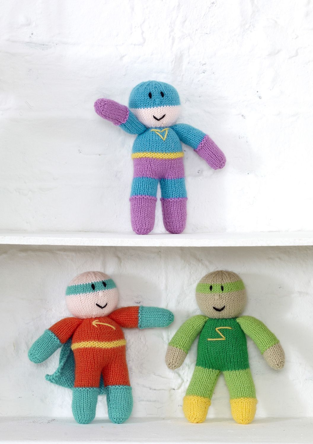 3 knitted superheroes in blue, purple, red and green.