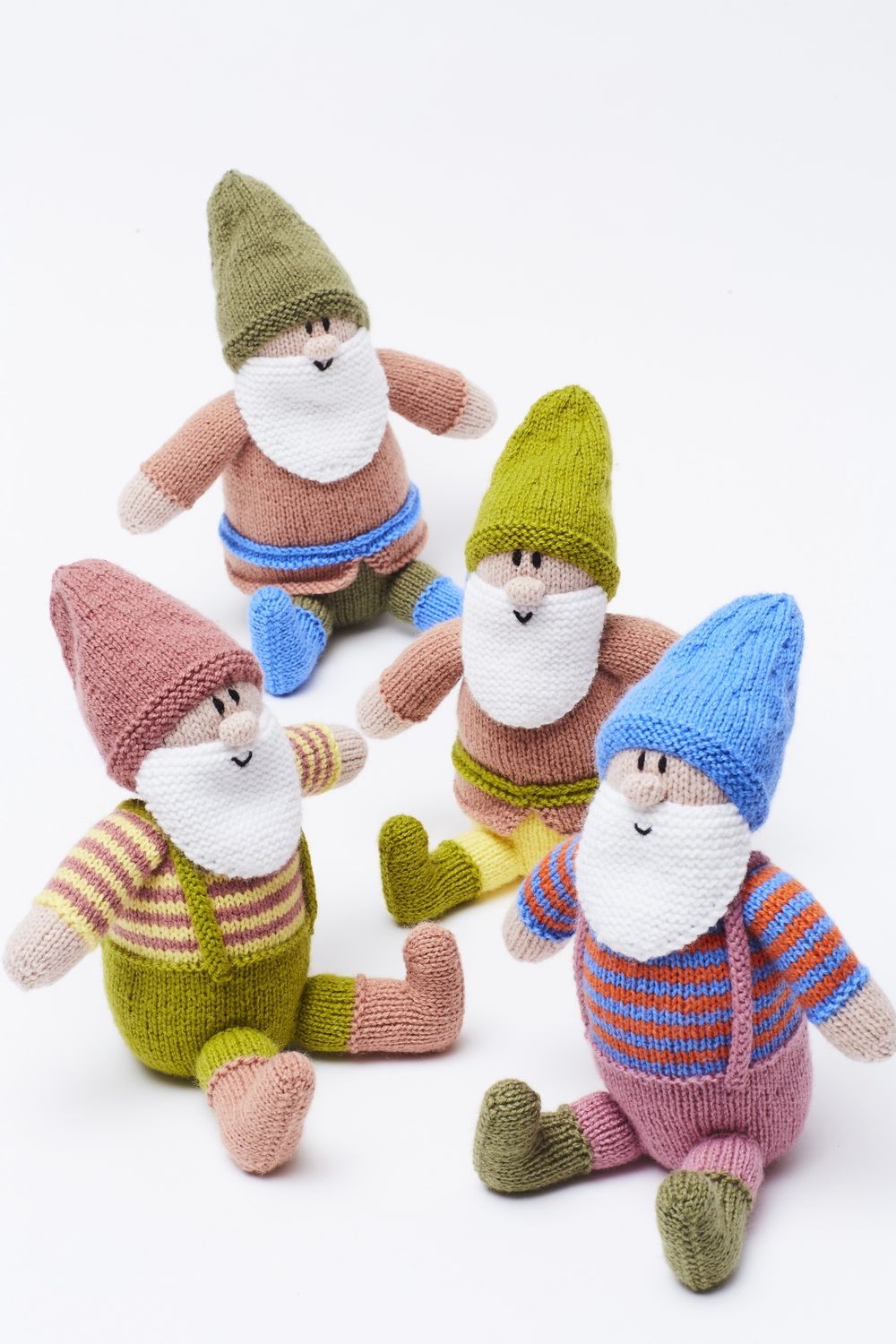4 knitted gnomes in greens, pinks and blues.
