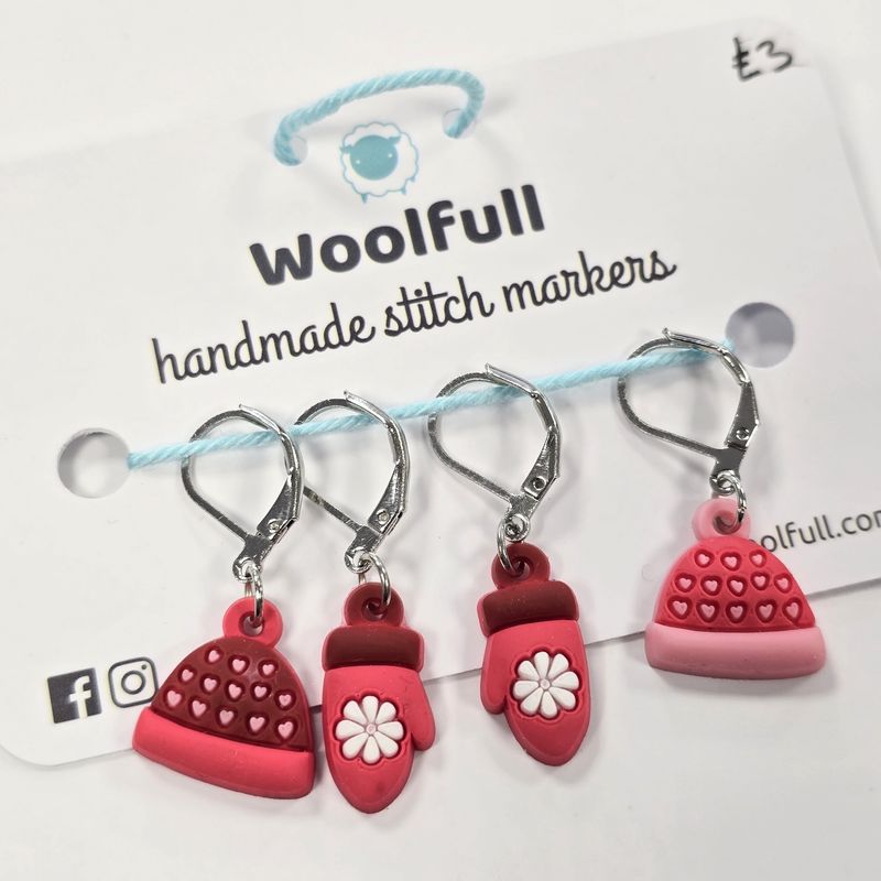 A photo of 4 stitch markers, 2 hat shaped and 2 mitten shaped.