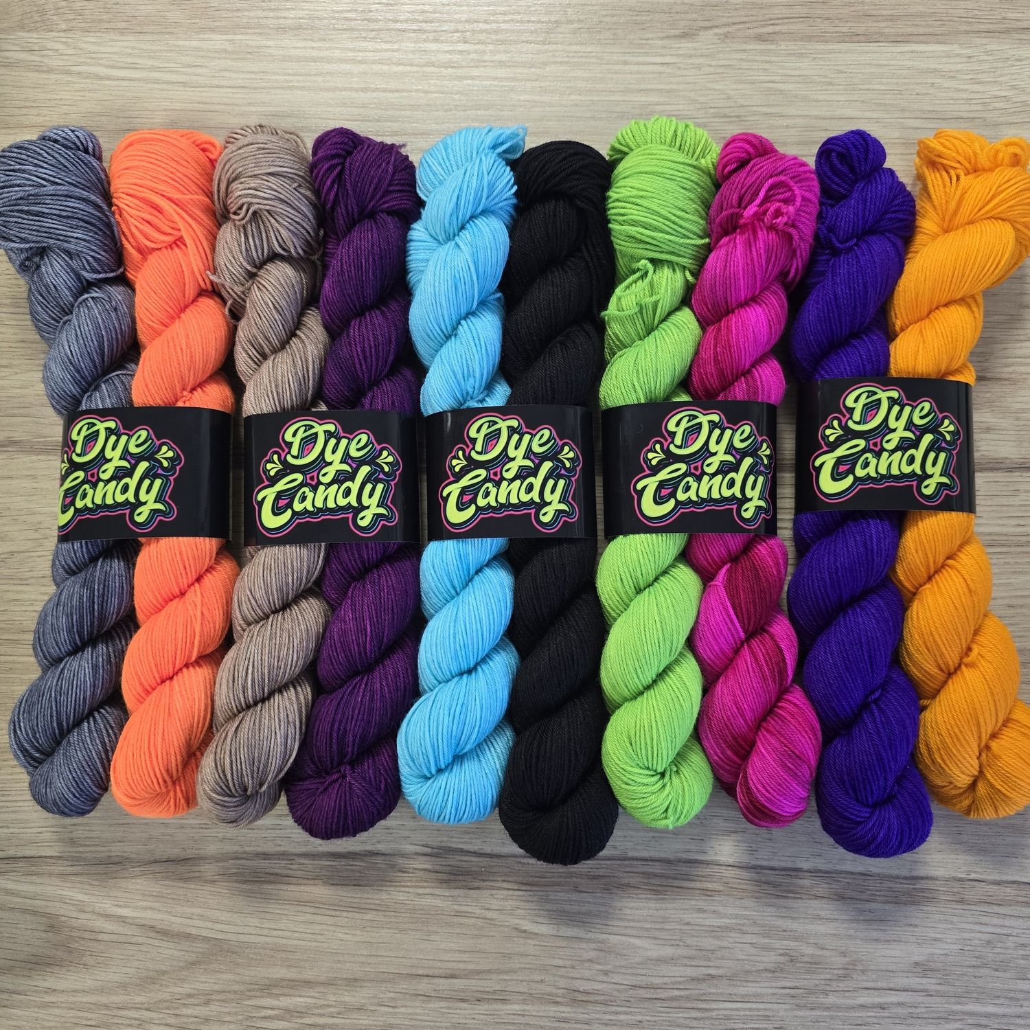 5 pairs of skeins, in grey and orange, brown and purple, aqua and black, green and pink and purple and orange.