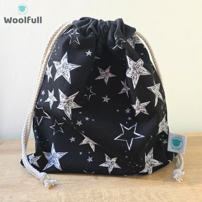 A drawstring bag in a black fabric with white stars.