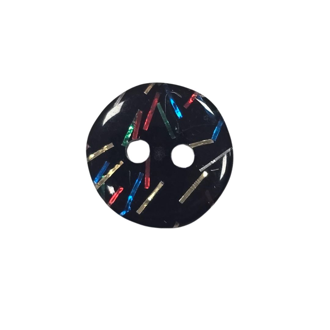 A black button with small red, blue, silver, gold and green pieces inside.