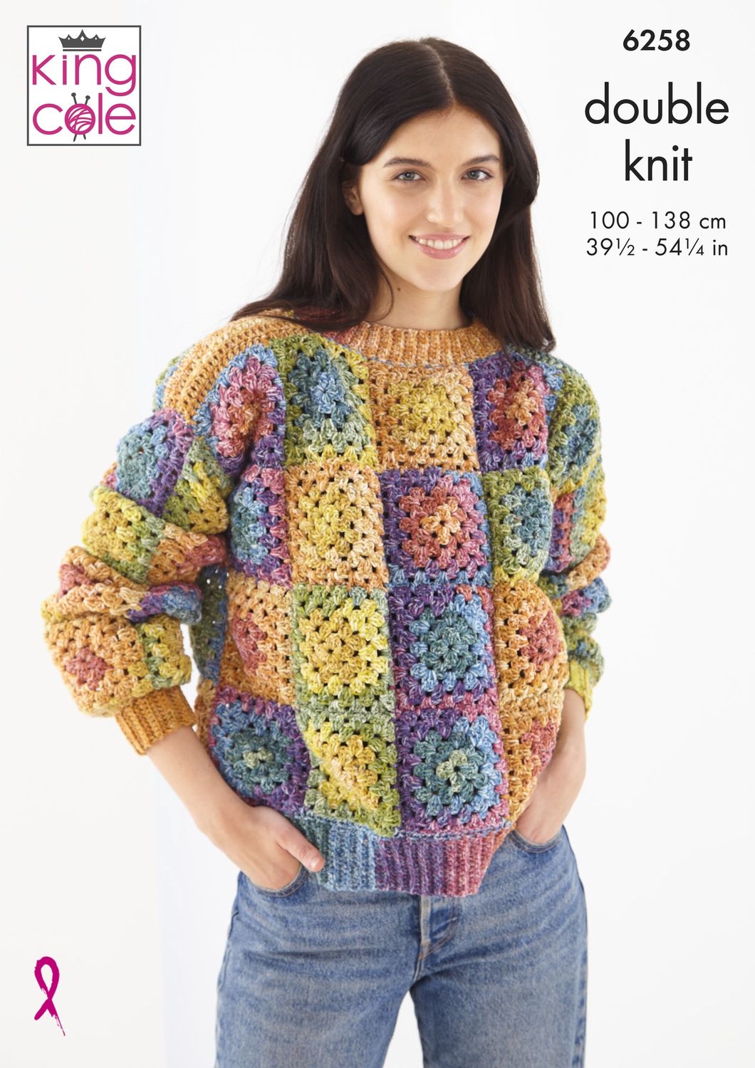 A woman is wearing a crocheted granny square sweater in a variegated yellow, green, blue and purple yarn.