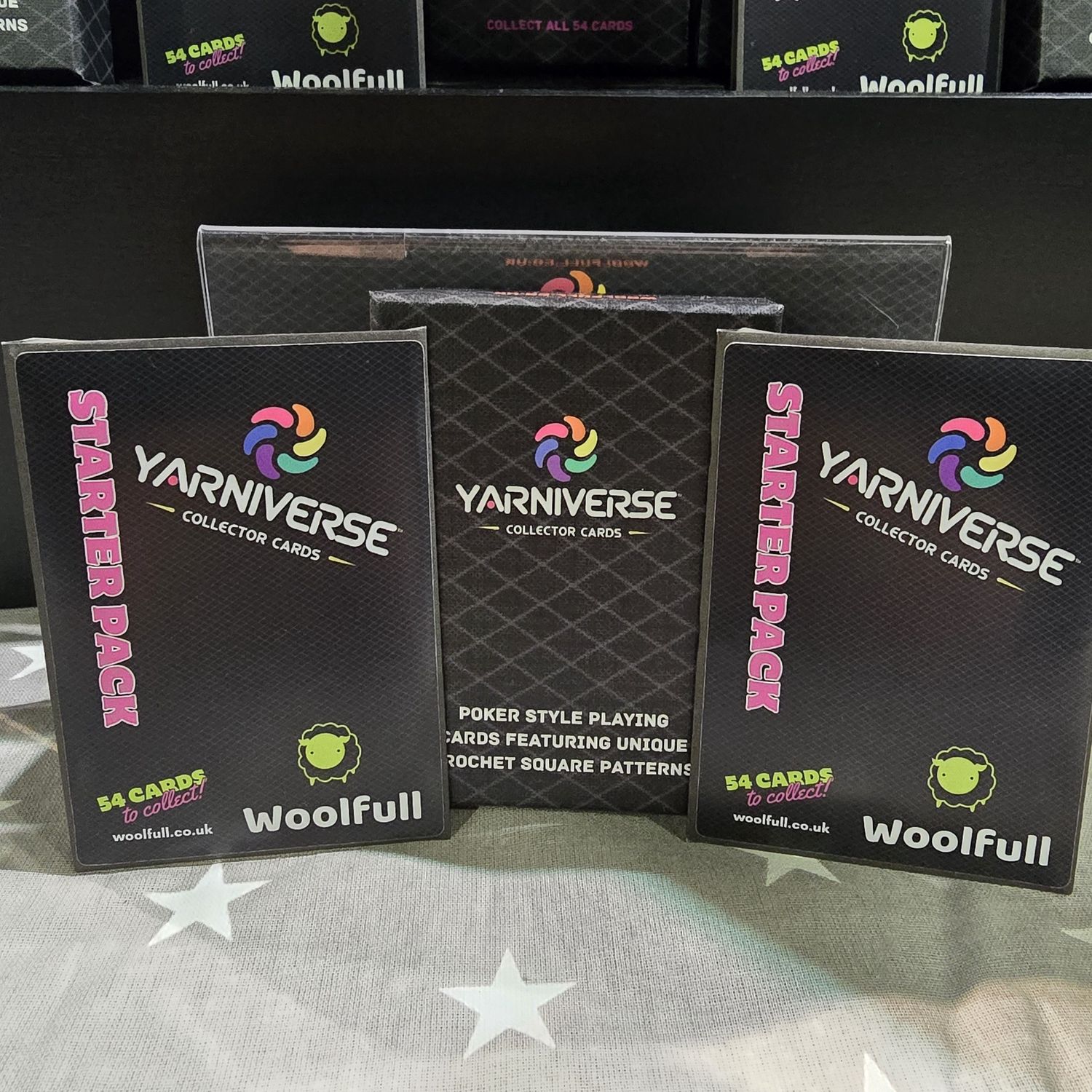 A Yarniverse deck box, alongside 2 Yarniverse starter pack envelopes.