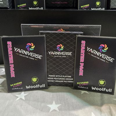 A Yarniverse deck box, alongside 2 Yarniverse starter pack envelopes.