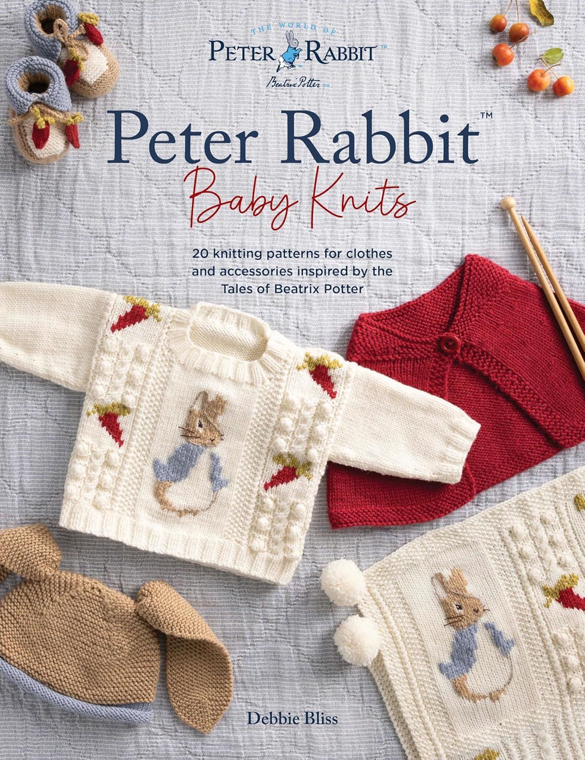 The front cover of the book, featuring a cream knitted baby jumper with a knitted Peter Rabbit on the front.