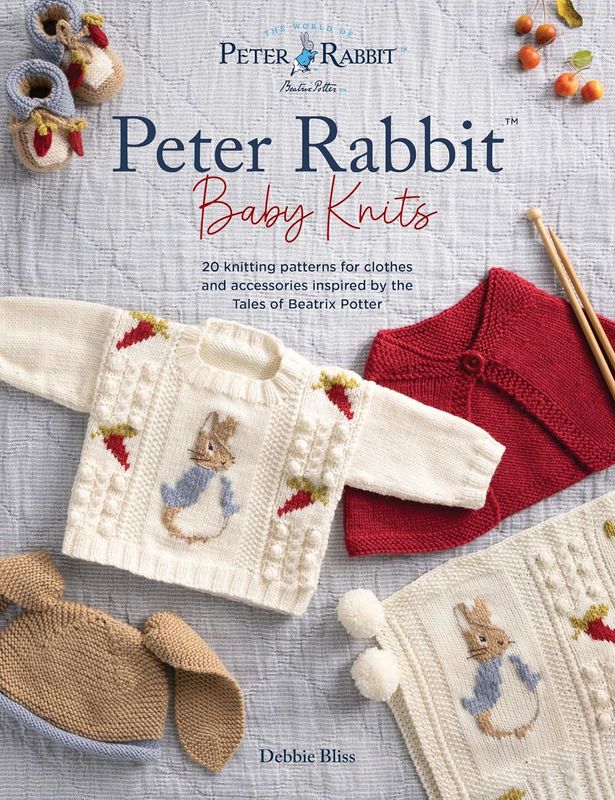 The front cover of the book, featuring a cream knitted baby jumper with a knitted Peter Rabbit on the front.