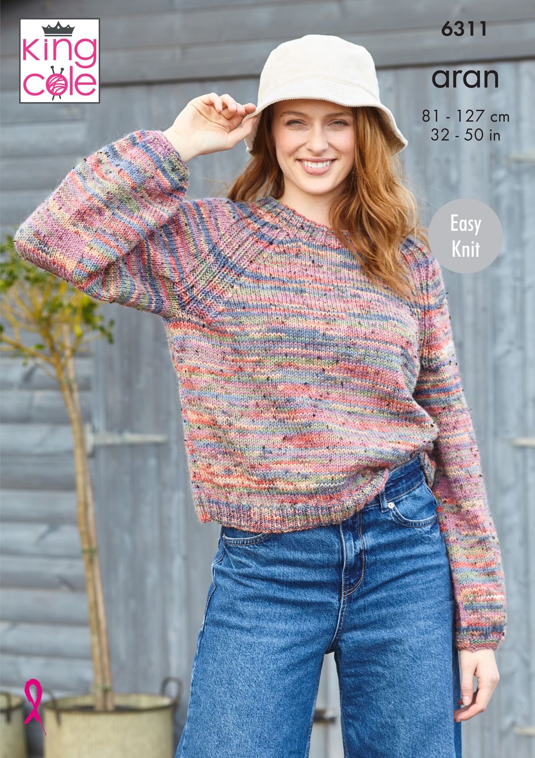 A woman is wearing a knitted sweater in a variegated pink, blue and green yarn.