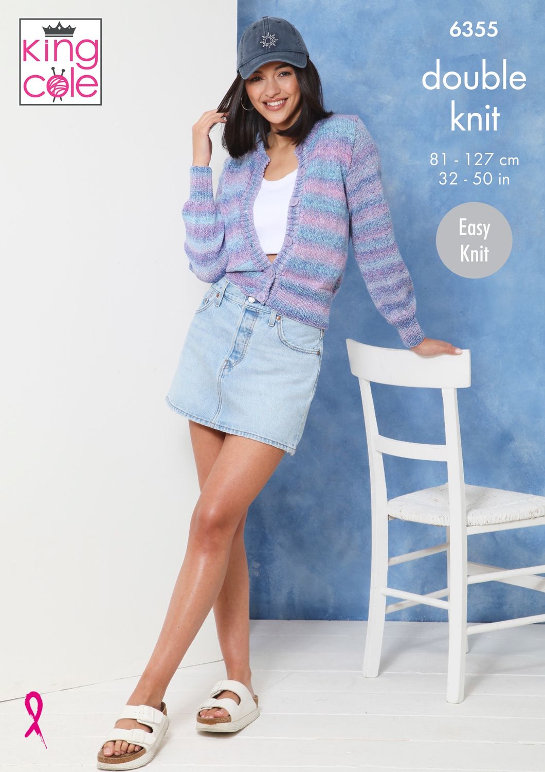 A woman is wearing a knitted cardigan in a variegated purple, pink and blue yarn.