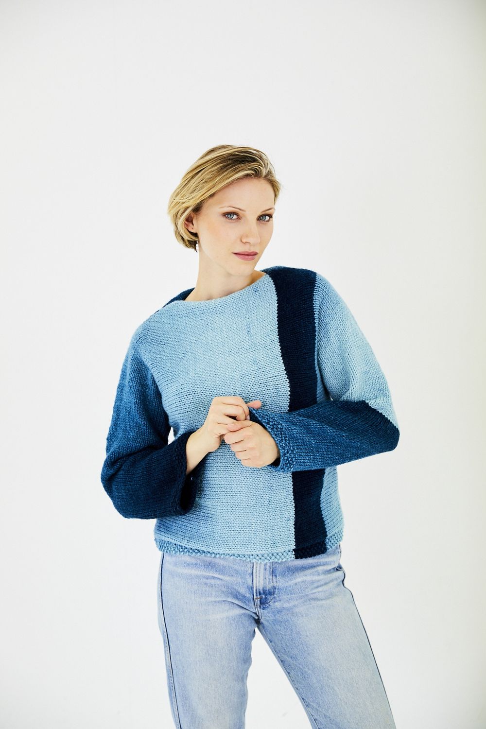 A woman is wearing a variegated blue knitted sweater.