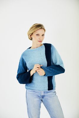 A woman is wearing a variegated blue knitted sweater.